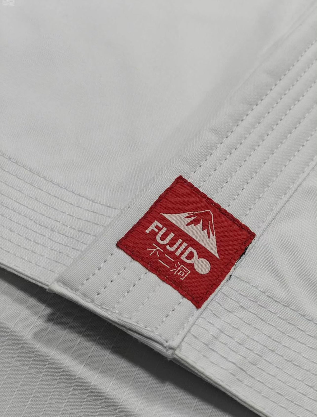 Fujido Kodiwara Kata Gi - gi laid out showing collar and sleeve embroidery detail